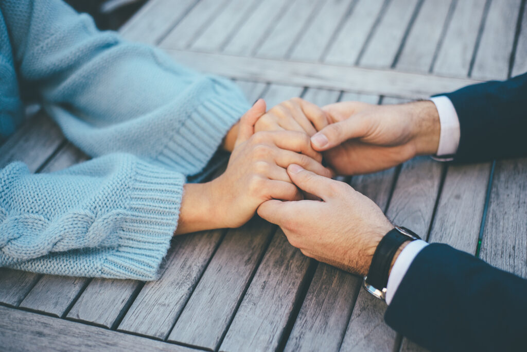 Closeup of young couple holding their hands